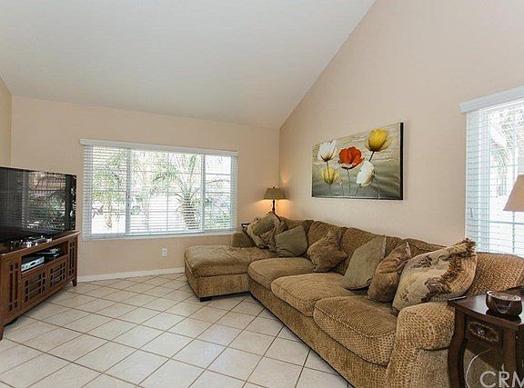 Family room has vaulted ceiling, tile floors and double-sided fireplace.