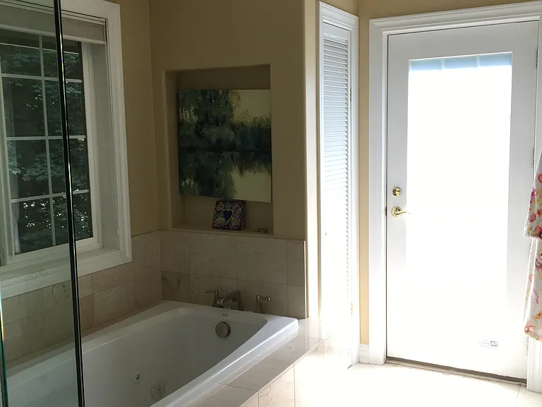 Exterior door leads to private patio. Whirlpool bathtub, water closet room other far right. Heated radiant tile floor.