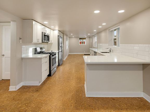 looking from living/rec area through kitchen to lower unit entrance - to left is 2nd bedroom, common bathroom and laundry area