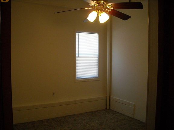 Bedroom has ceiling fan and high ceilings