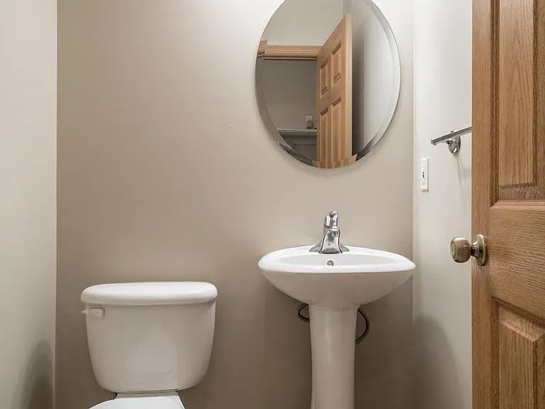 The hallway bathroom features a sleek pedestal sink.