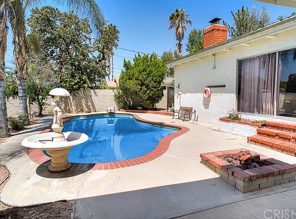 The relaxing backyard with sparkling pool, a fire pit, and RV parking access.