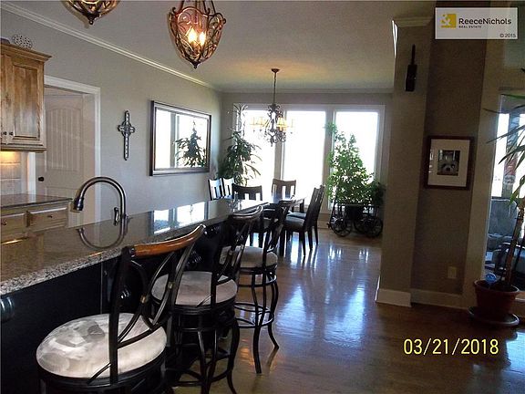 View across the Kitchen Island toward the Dining Area with Floor to Ceiling Windows for natural lighting.