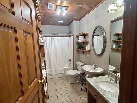 Full-size bathroom with custom shelving & drawers, LED lighting/fixtures, tile floor, large vanity with built-in shelves, storage, drawers and more.