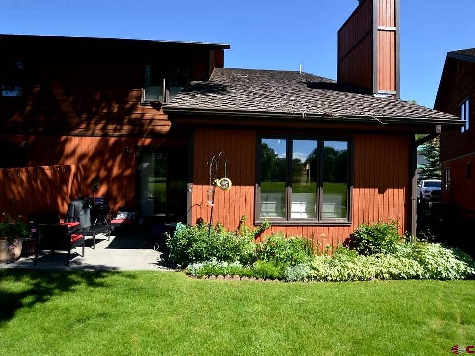 Landscaping and lush lawn with concrete patio.