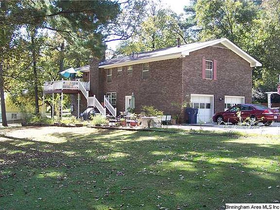 THE REAR VIEW SHOWS THE DECK FOR GRILLING OUT AND THE LARGE PATIO AREA