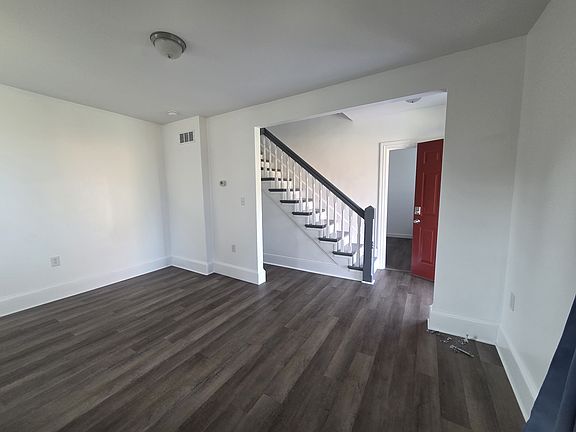 Enter the front door to the staircase. On the left is the large living room. On the right is a 3rd bedroom or office space. Straight back will take you to the kitchen.