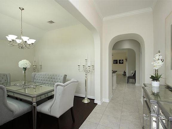 THE DINING ROOM HAS AN ARCHITECTURAL ACCENTED CEILING AND BEAUTIFUL WOOD FLOORS. NOTE THE PRETTY ARCHES THAT YOU WILL SEE THRU OUT THE HOUSE. TILE IN THE ENTRY, KITCHEN, UTILITY, FAMILY ROOM AND BATHROOMS.