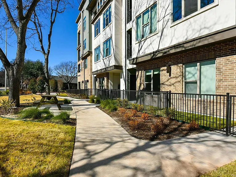 Outdoor Walking Path with Trees, Benches, and Apartment Views