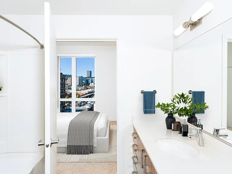 A bright primary bath at Modera Belmont, featuring clean finishes and generous storage, with Belmont's walkable shops and cafes just outside.