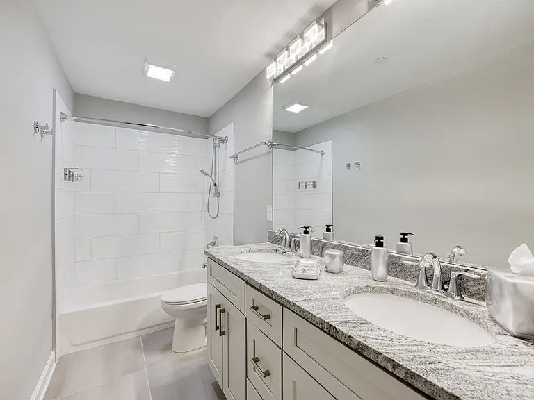 The second bathroom features a spa-like double vanity and a bathtub.