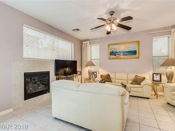 Living room has a fireplace and ceiling fan...