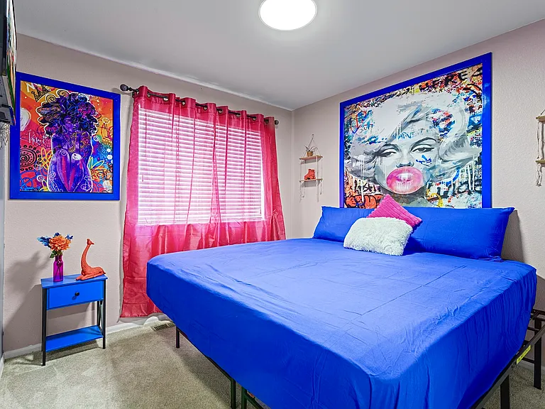 Bright and airy bedroom with a comfortable king-size bed and colorful decor. Perfect for a restful night's sleep.