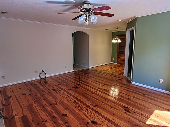 Living and dining area features heart pine flooring, built in hutch in dining area.