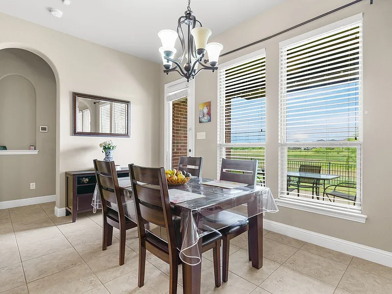 Casual dining in the kitchen while admiring the backyard views. Right door to the covered patio. Left archway leads to the primary suite.