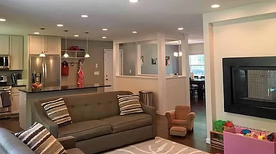 View from the living room into the kitchen and dining area. Through the fireplace you can see the office/den