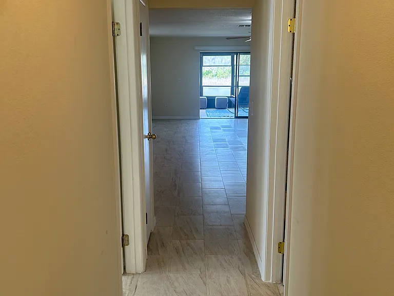 photo from the back of the bedroom hallway to sliding glass doors to patio and yard