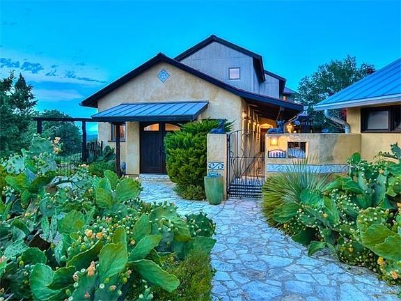 The main entry is through the custom forged courtyard gate.  This sustainable home is the fusion of Spanish and contemporary design.