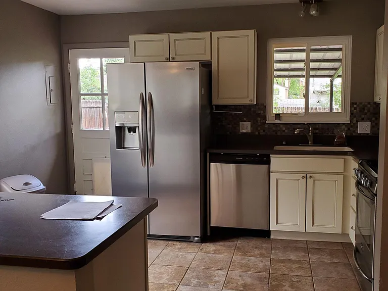 Kitchen has custom cabinets, stainless steel applicances: side-by-side refrigerator/freezer, dishwasher and gas range. Kitchen no longer has ceramic tile, it now has new luxury vinyl flooring.
