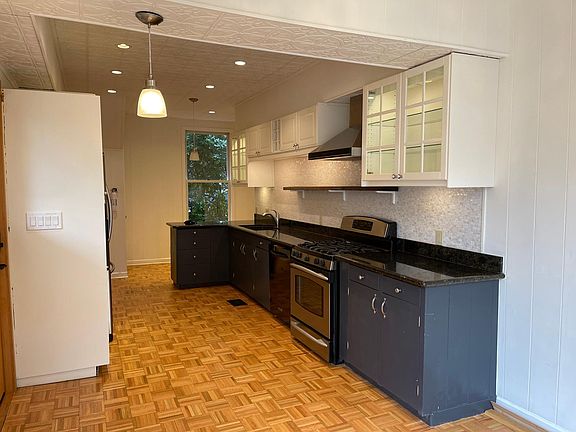 Large open kitchen with gas range, dishwasher, microwave and refrigerator.
