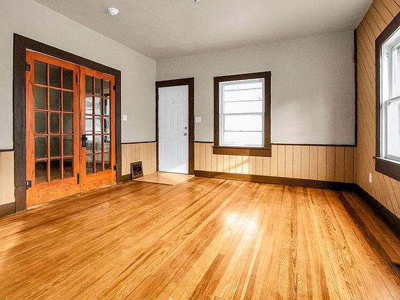 Living room with hardwood floors. French doors lead to master bedroom. White door is the front door of the house.
