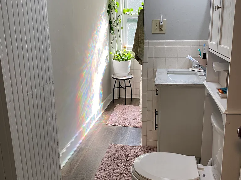 Bathroom with newer flooring, vanity and toilet.