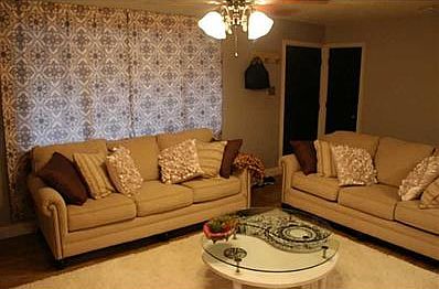 Family Room. Another view of the family room. The front door is located on the left. There is a walk way between the doors and the couch. Much more spacious feel than in photographs. The right door is a linen closet.