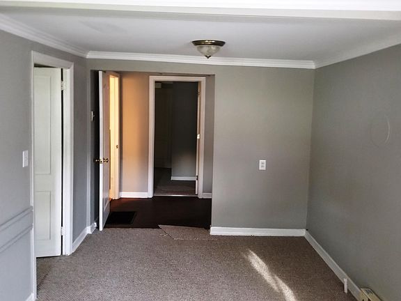 Front room viewed from Front door, looking back to kitchen and back bedroom. Second bedroom door on left, then bathroom door on left.