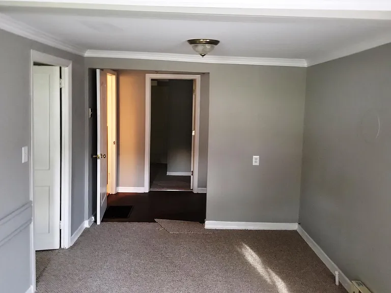 Front room viewed from Front door, looking back to kitchen and back bedroom. Second bedroom door on left, then bathroom door on left.