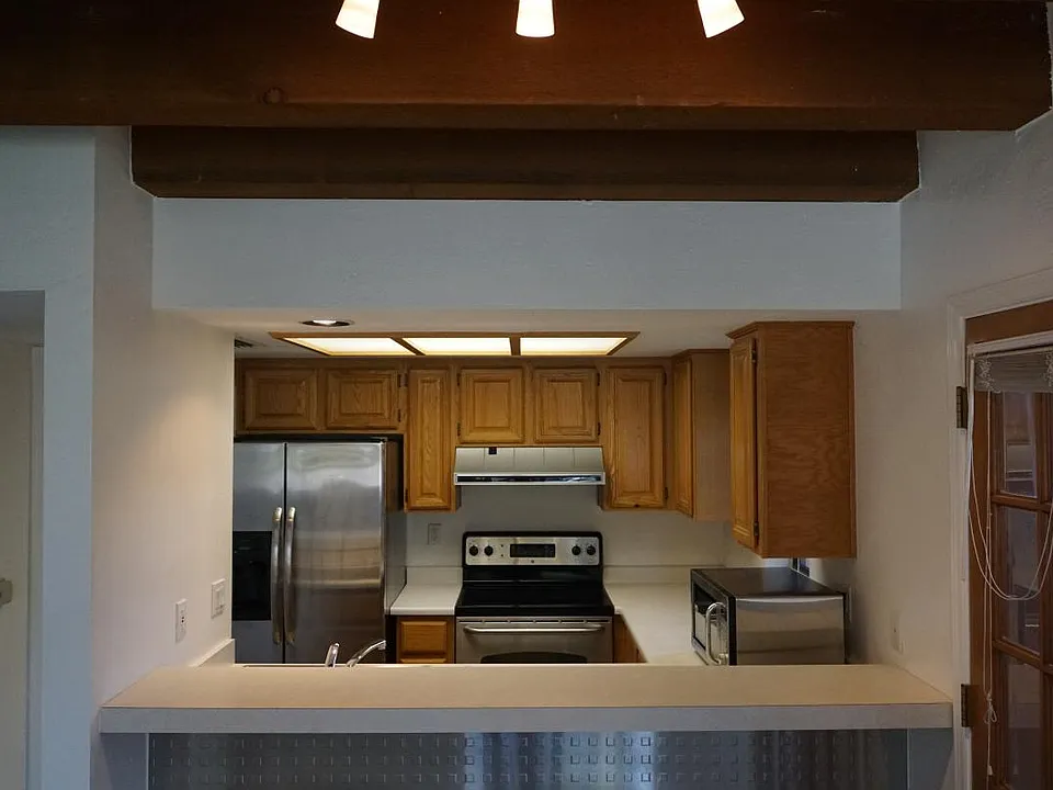 Kitchen, highlighting high ceilings in living room area.