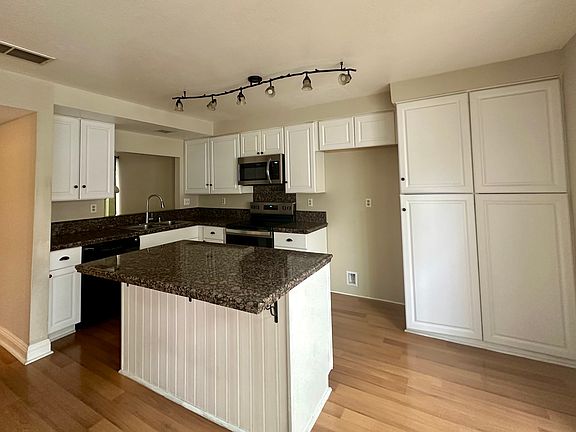 Kitchen with an island containing storage cabinets.