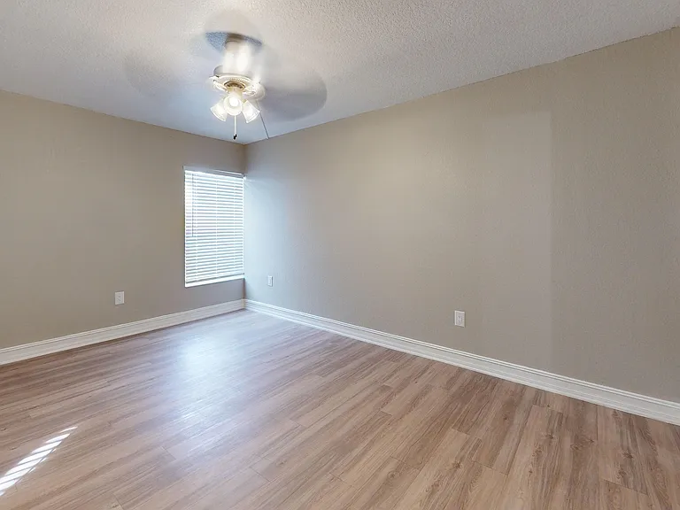 Step into comfort with this cozy bedroom featuring elegant hardwood floors.