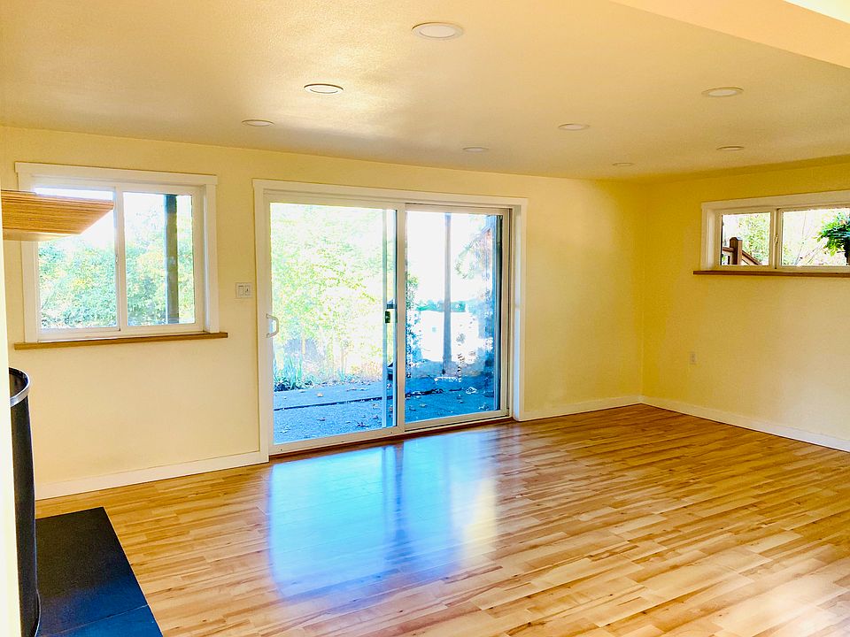 Living room facing backyard, flower beds and view of mountains.