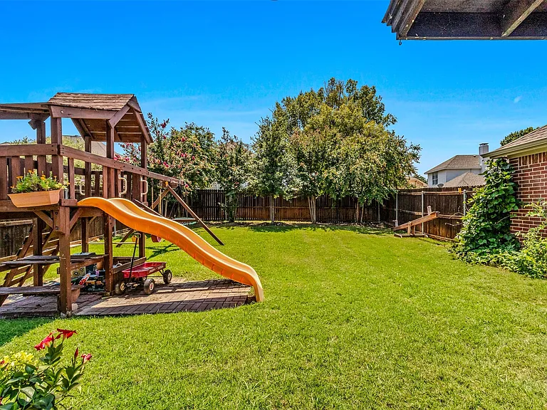 Expansive green lawn with a privacy fence