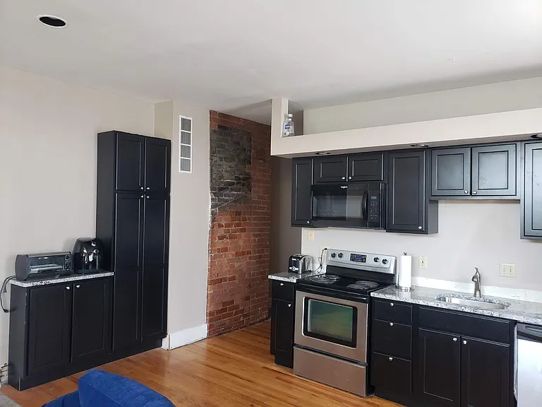Updated kitchen with black cabinets with granite tops & stainless appliances with microwave over the range