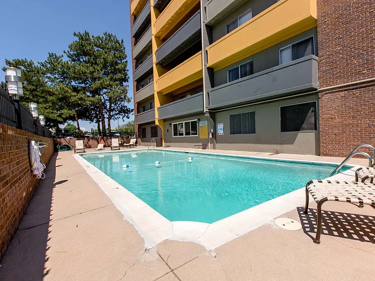 Resort-style pool with sunny deck and shaded seating