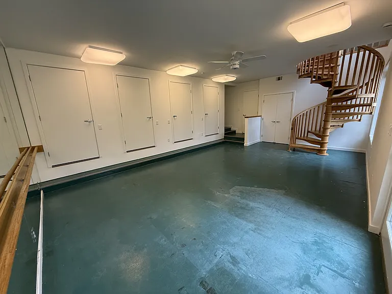 Exercise studio features a mirrored wall, multiple storage closets and a patio door to a cozy deck and the wrap around hanging walkway.