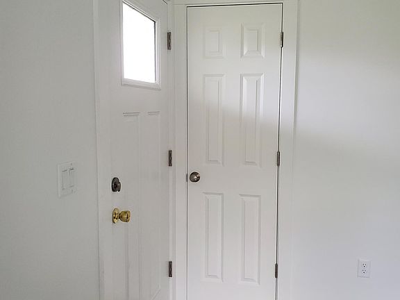 front door white walls & grey flooring. will have curtains & area rugs for living room & bedroom