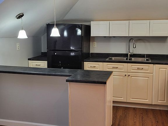 Kitchen includes stove, refrigerator and microwave.