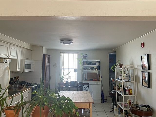 Sunny, roomy eat-in kitchen with gas stove, microwave, fridge/freezer, and washer/dryer. Tile flooring.