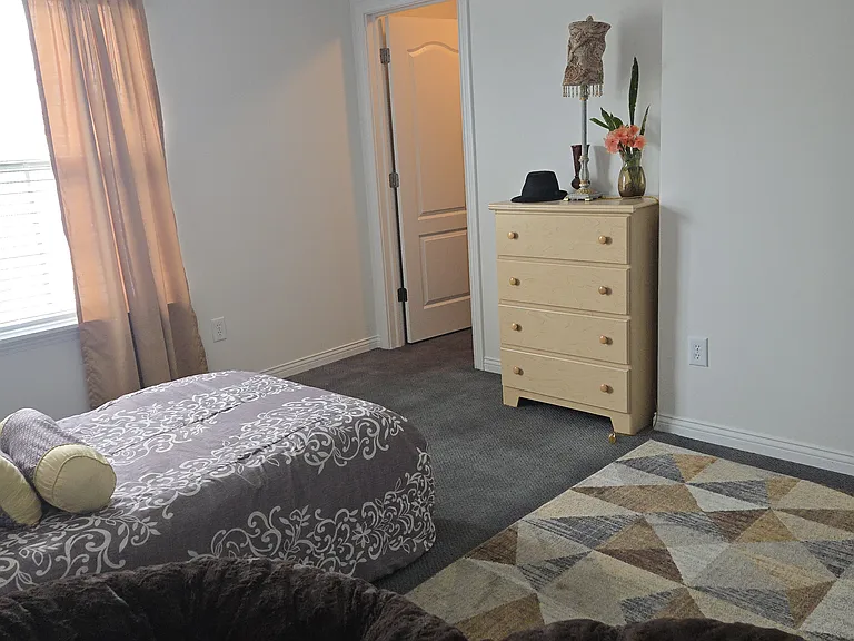 Bedroom 2: twin bed, dresser, walk-in closet, area rug, remote-controlled ceiling fan, curtains