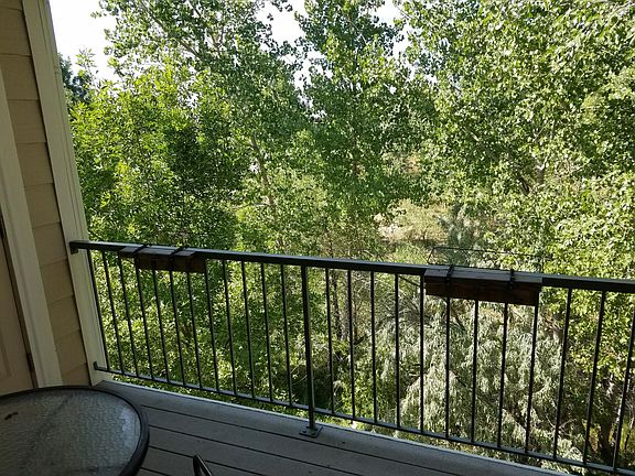 Balcony off living room overlooks quiet green space.