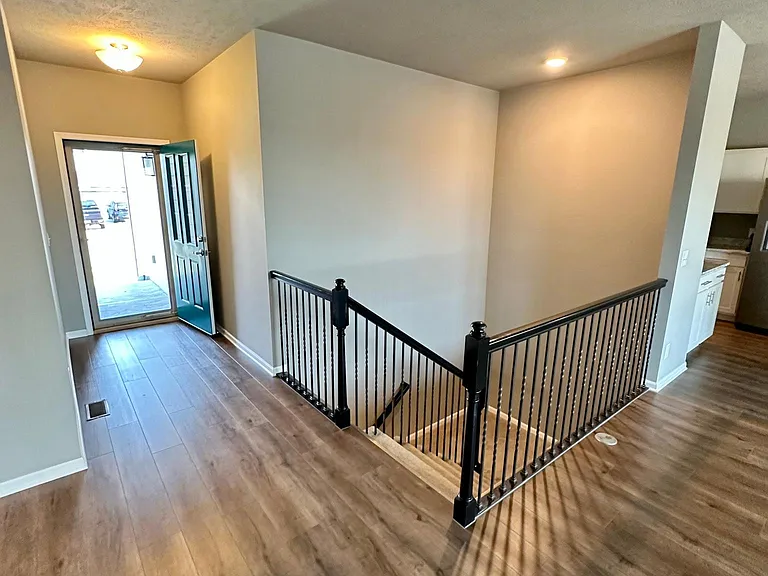 Entryway and switchback stairs down to basement