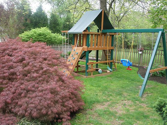 1.6 acres, fenced area with slate patio, specimen plantings & new swingset