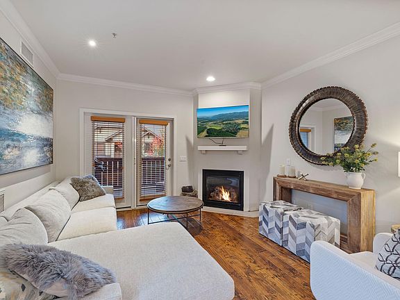 Main (2nd) level living room with a plush sectional sofa and arm chair, gas fireplace and 55" smart TV