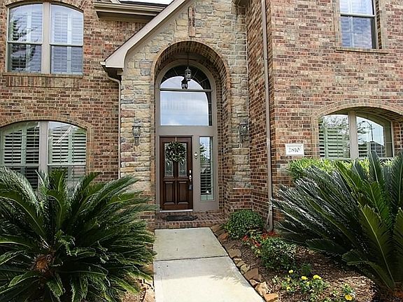 The inviting covered entry is accessed by the walkway lined with landscaping. A beautiful home ready