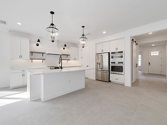 Kitchen with floating shelves and pendant lights