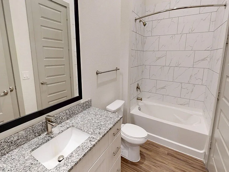 Apartment Bathroom with large soaking tub and Wood Style Flooring.