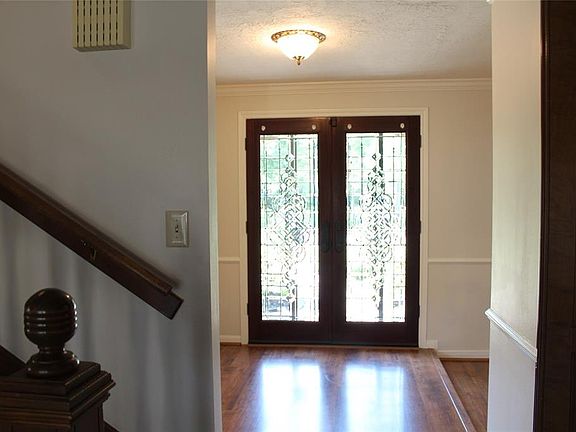 Front entrance foyer with wood laminate floors and leaded glass double doors.