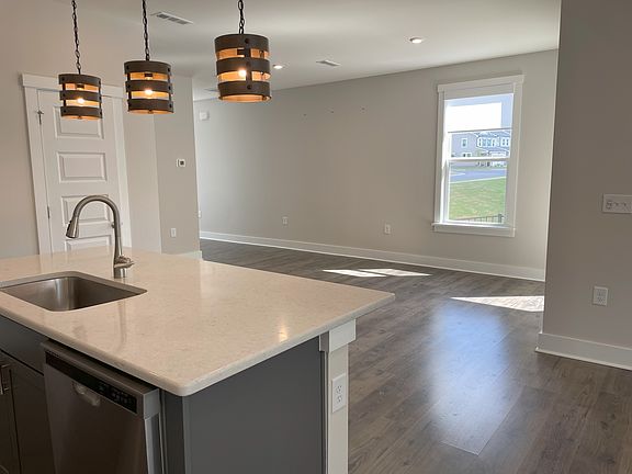 Dining area opposite kitchen island, opens to sunny balcony